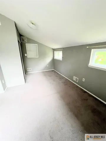 a view of a big room with wooden floor and windows