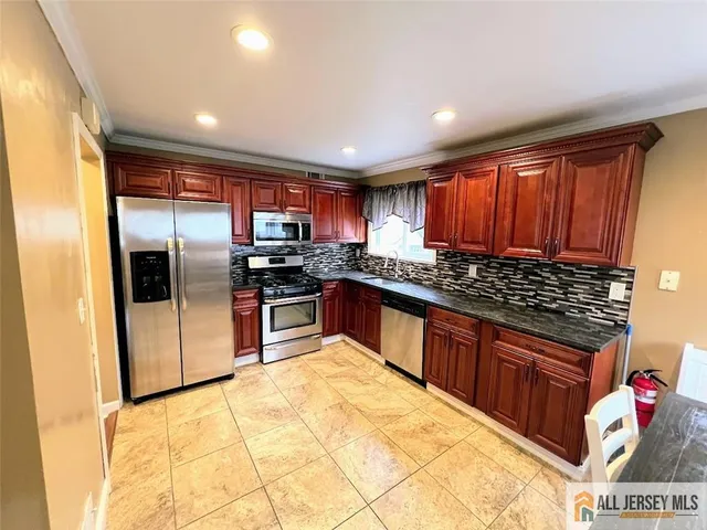 a kitchen with stainless steel appliances granite countertop a stove a sink dishwasher a refrigerator and cabinets with wooden floor
