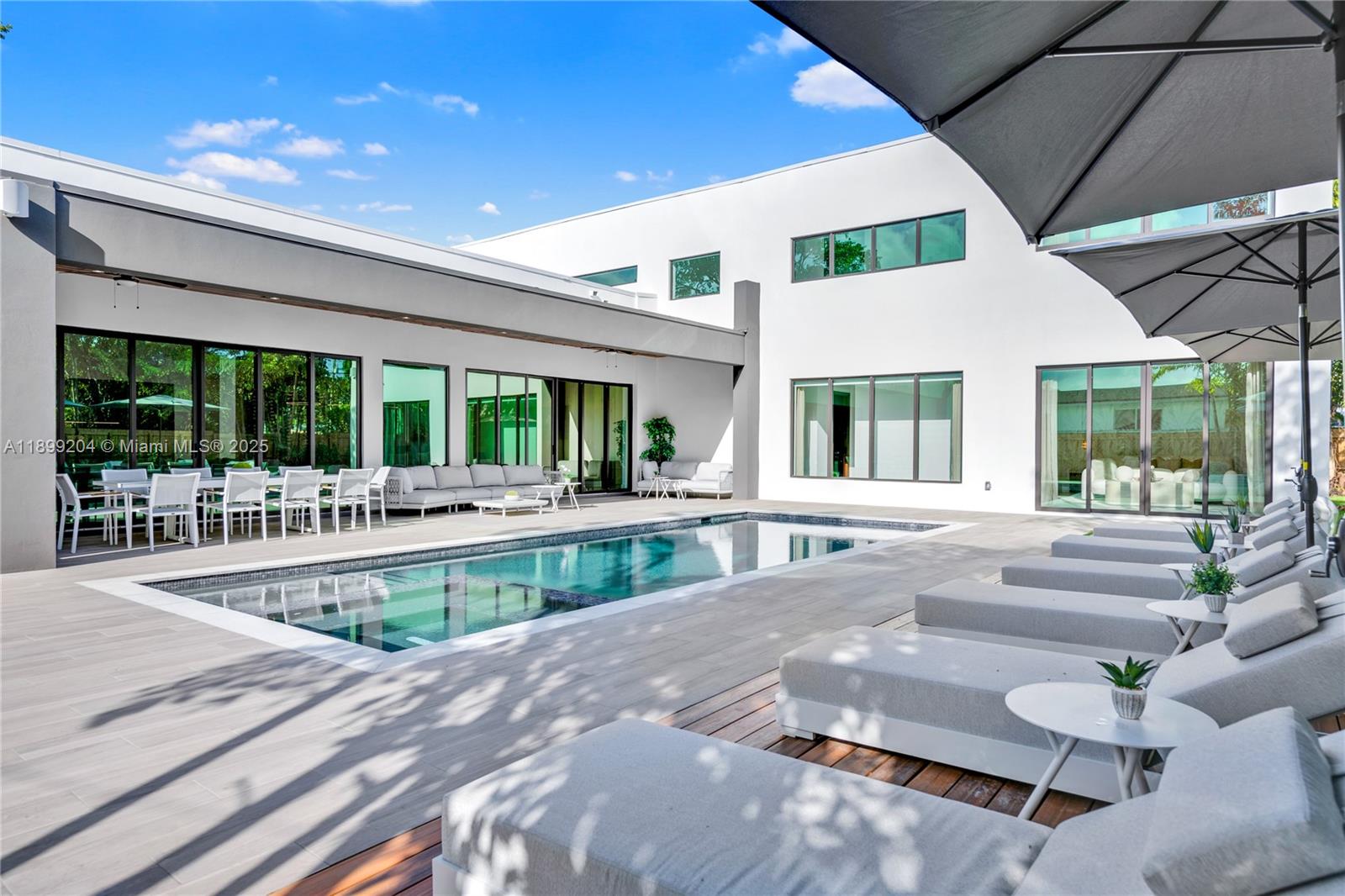 2110 Northeast 197th Terrace Miami, FL 33179 - Photo 25 of 77 a view of a patio with couches table and chairs and potted plants