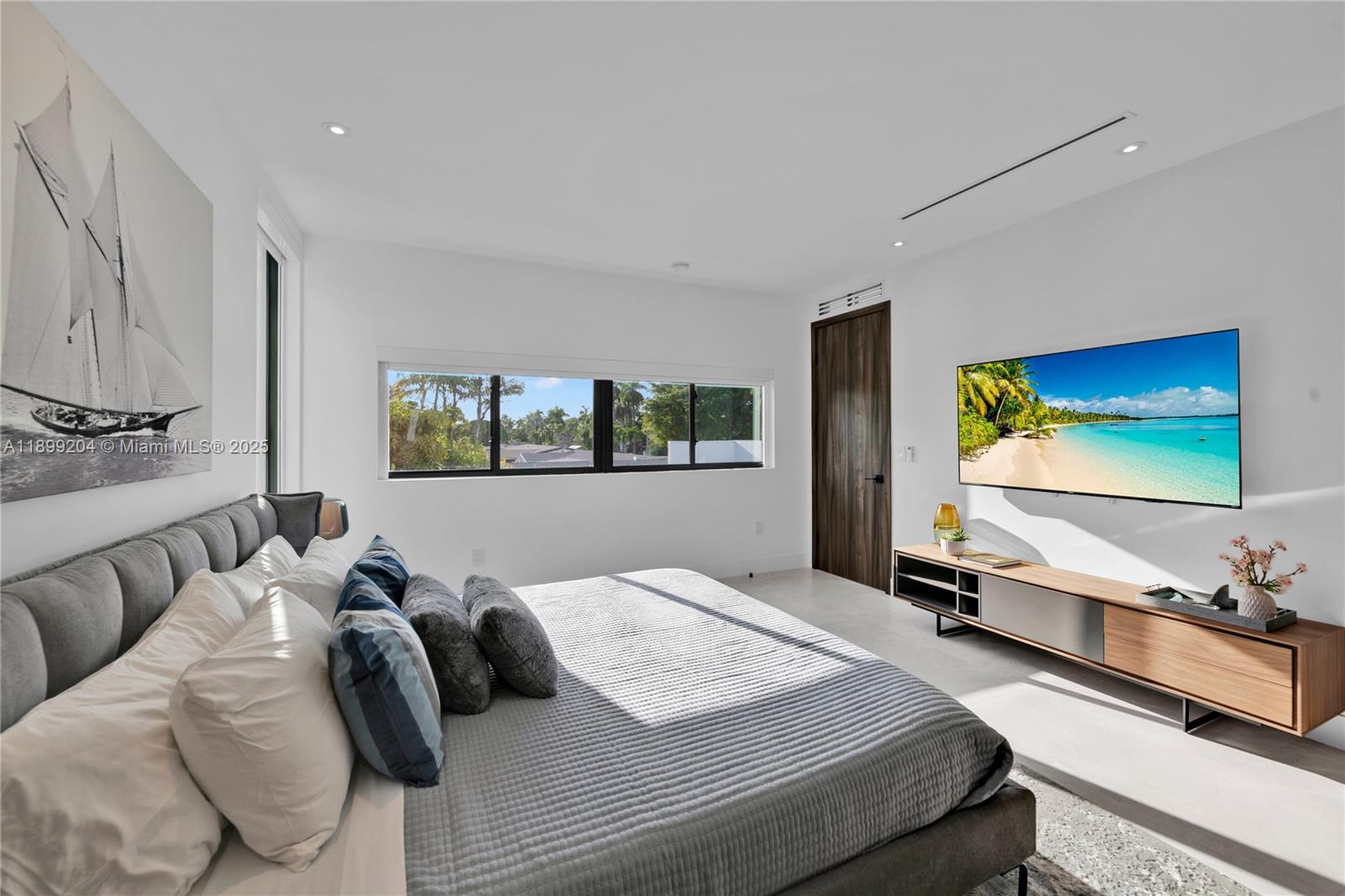 2110 Northeast 197th Terrace Miami, FL 33179 - Photo 41 of 77 a bedroom with a bed and glass wall