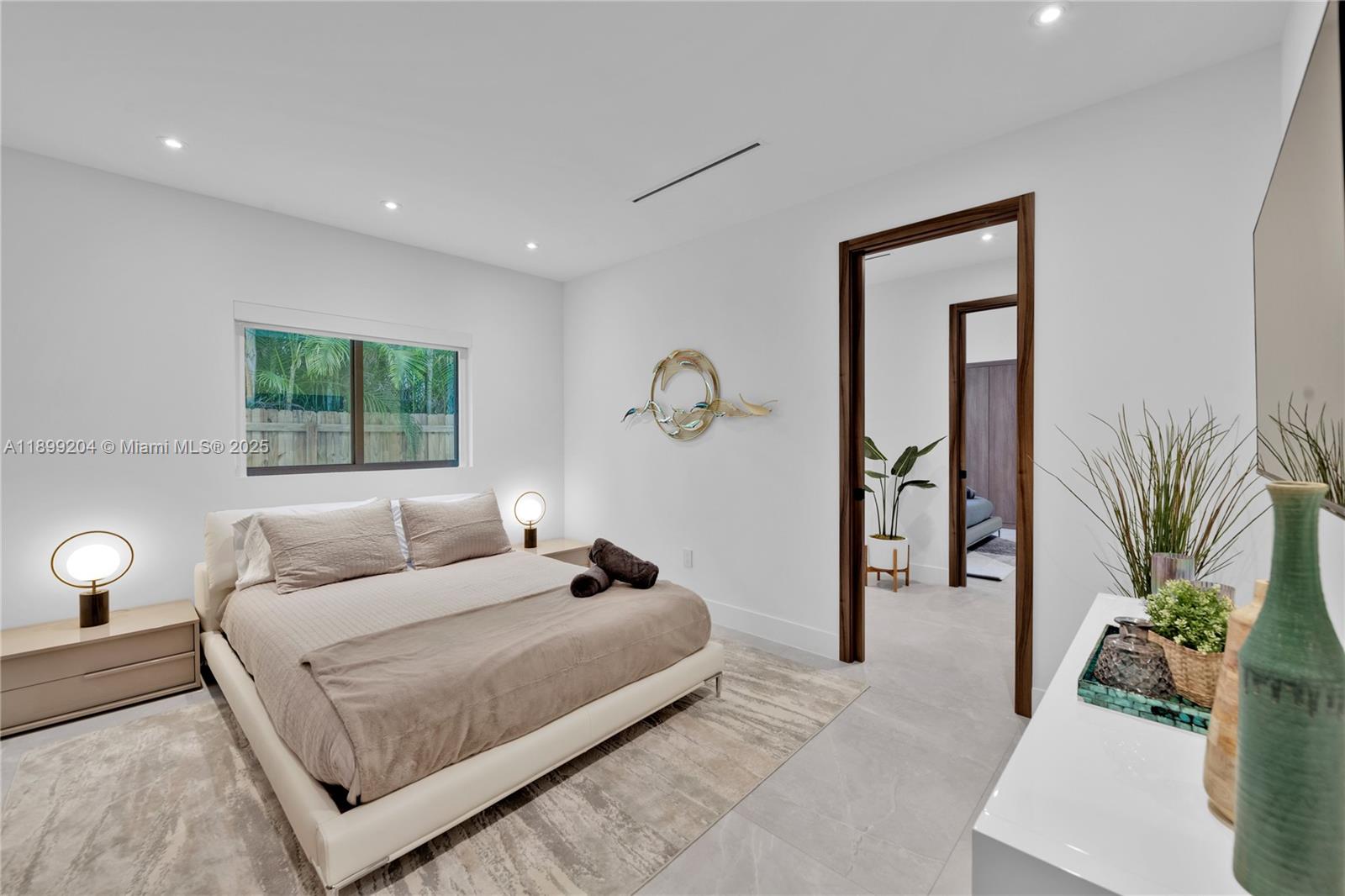 2110 Northeast 197th Terrace Miami, FL 33179 - Photo 44 of 77 a bedroom with a large bed and a potted plant