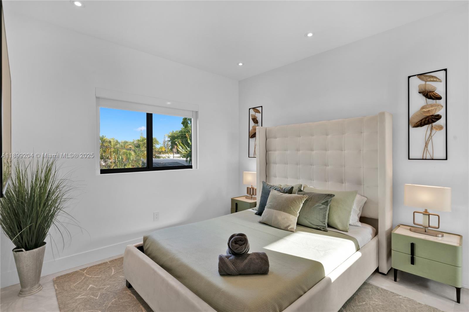 2110 Northeast 197th Terrace Miami, FL 33179 - Photo 59 of 77 a bedroom with a bed and a potted plant