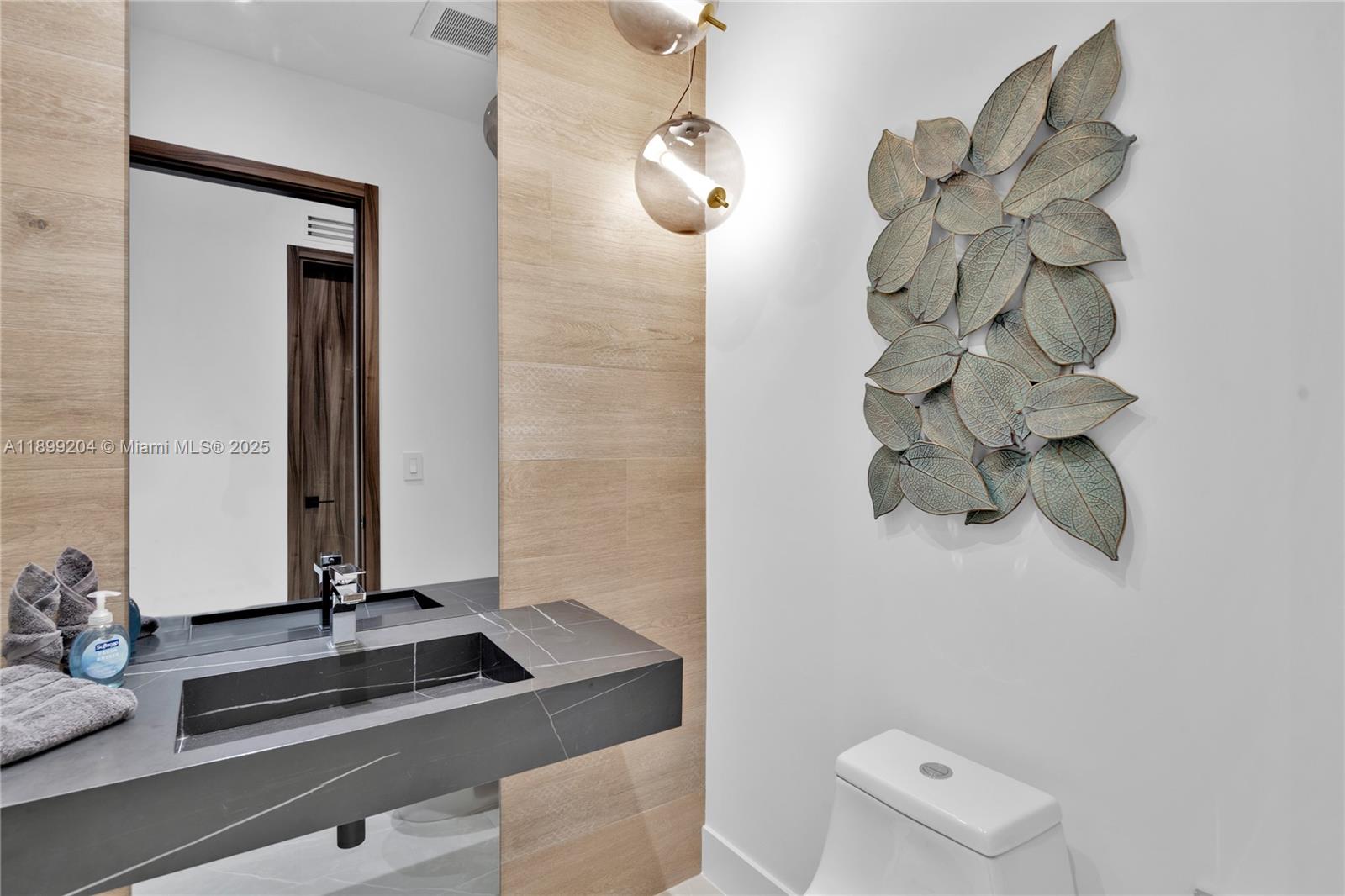 2110 Northeast 197th Terrace Miami, FL 33179 - Photo 10 of 77 a bathroom with a sink a mirror and vanity