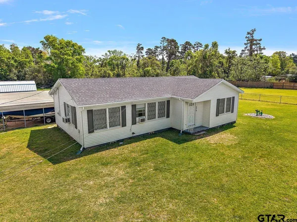 a aerial view of a house with a yard table and chairs