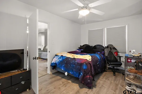 a bedroom with a bed and a flat tv screen on wall