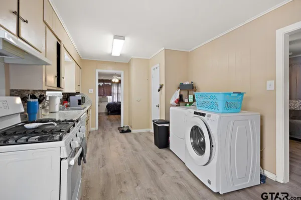 a kitchen with a stove and wooden floor