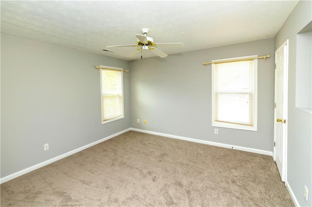 3440 Maple Valley Drive Cumming, GA 30040 - Photo 16 of 23 an empty room with windows and chandelier fan
