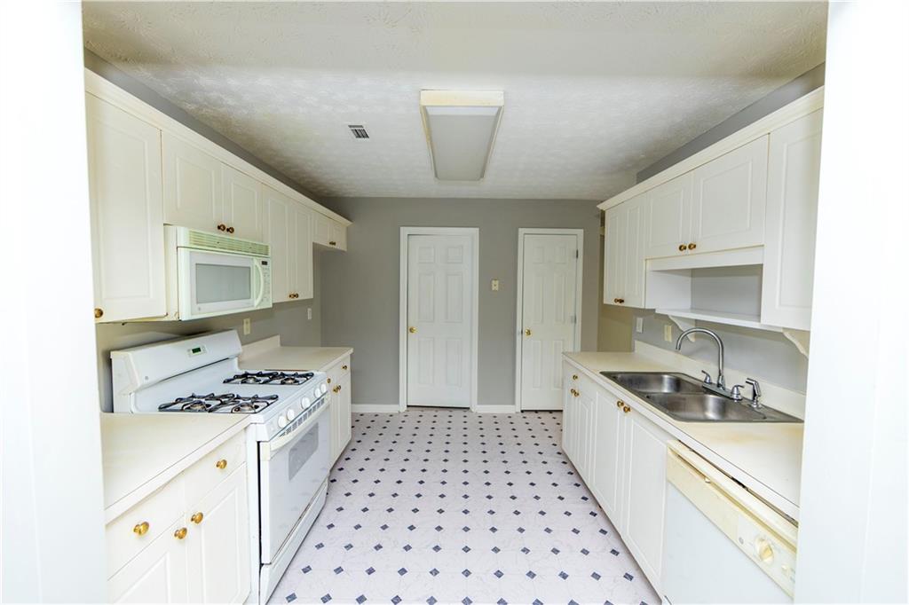 3440 Maple Valley Drive Cumming, GA 30040 - Photo 6 of 23 a kitchen with granite countertop a sink stove and cabinets