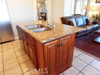 2 Los Palos Aliso Viejo, CA 92656 - Photo 6 of 32 a kitchen with granite countertop a sink a stove and a wooden cabinets