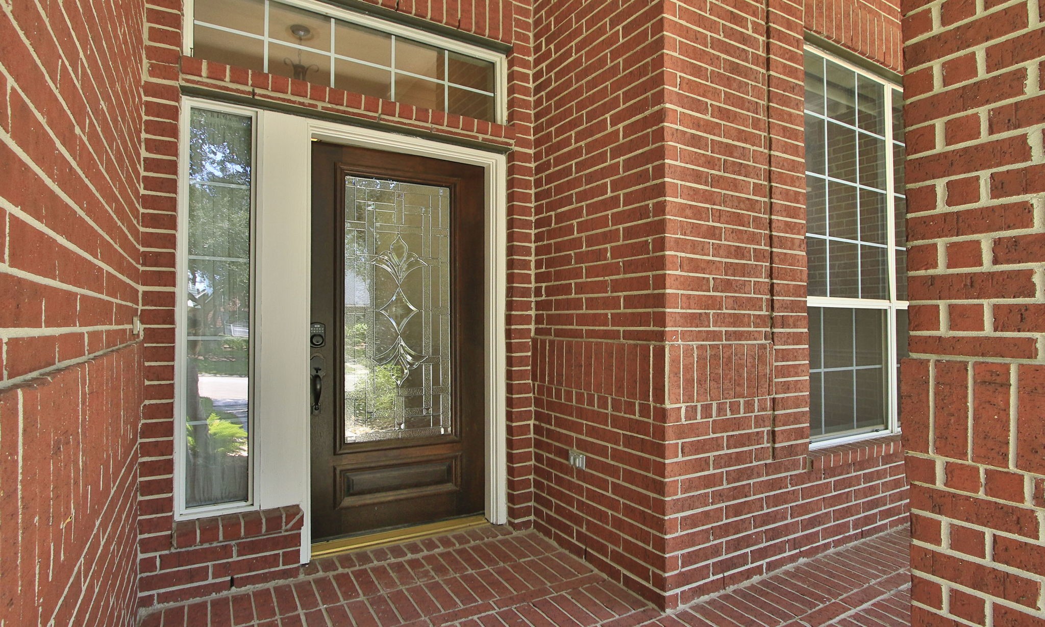 6311 Stone Trail Lane Spring, TX 77379 - Photo 6 of 47 Elegant glass and wood front door, with a thoughtfully placed exterior outlet for holiday decorations