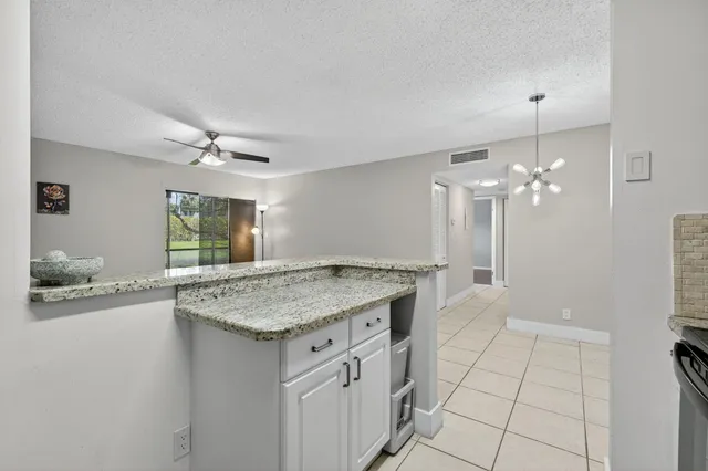 a kitchen with a sink cabinets and chandelier