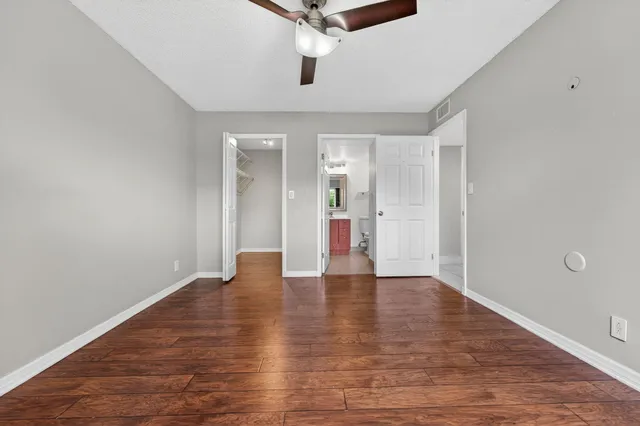 a view of an empty room with wooden floor