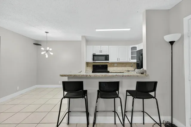 a kitchen with stainless steel appliances a stove a sink cabinets and a dining table