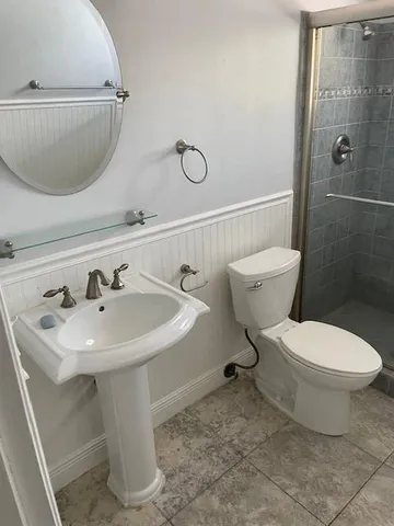 a bathroom with a sink toilet and shower
