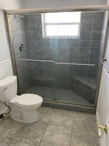 a bathroom with a toilet and a shower