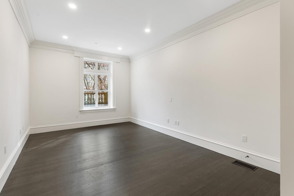 409 Commonwealth Avenue, Unit B Boston, MA 02215 - Photo 25 of 42 an empty room with wooden floor and windows