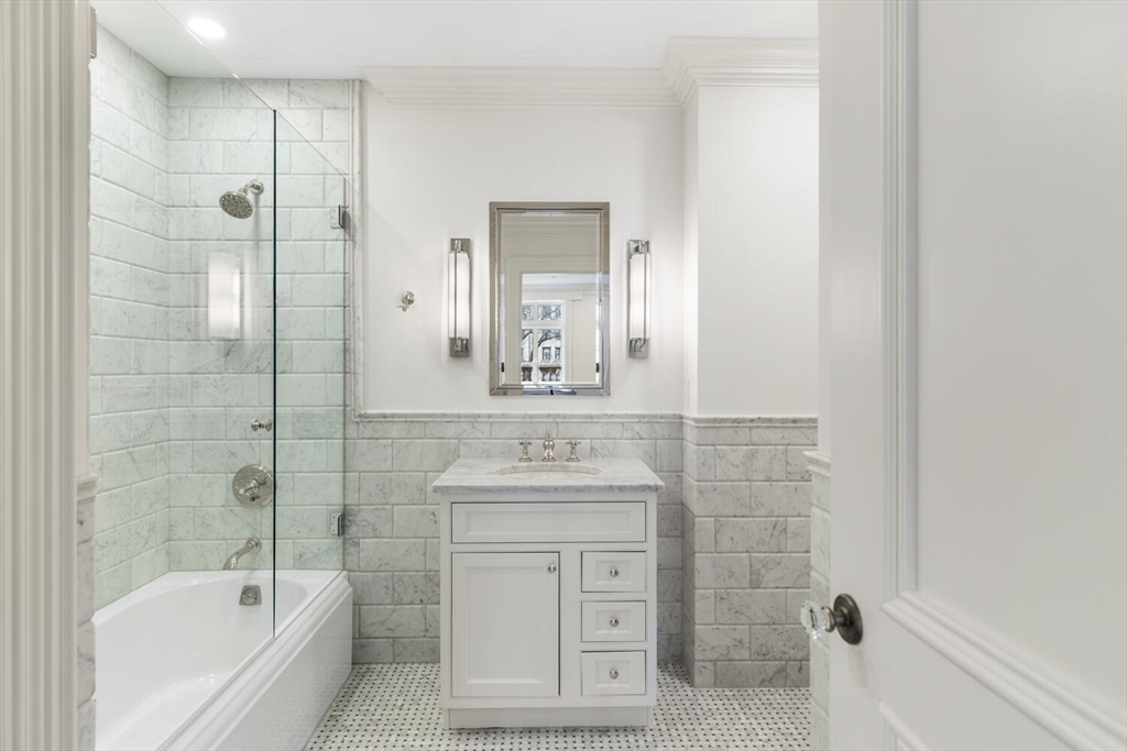 409 Commonwealth Avenue, Unit B Boston, MA 02215 - Photo 26 of 42 a bathroom with a granite countertop sink a mirror bathtub and shower