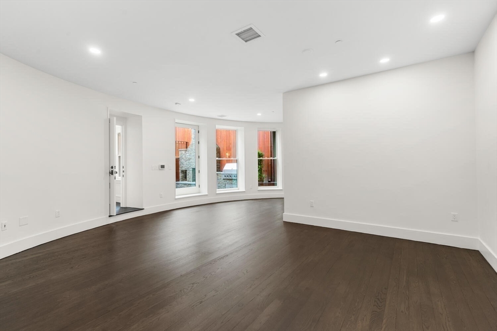 409 Commonwealth Avenue, Unit B Boston, MA 02215 - Photo 28 of 42 an empty room with wooden floor and windows
