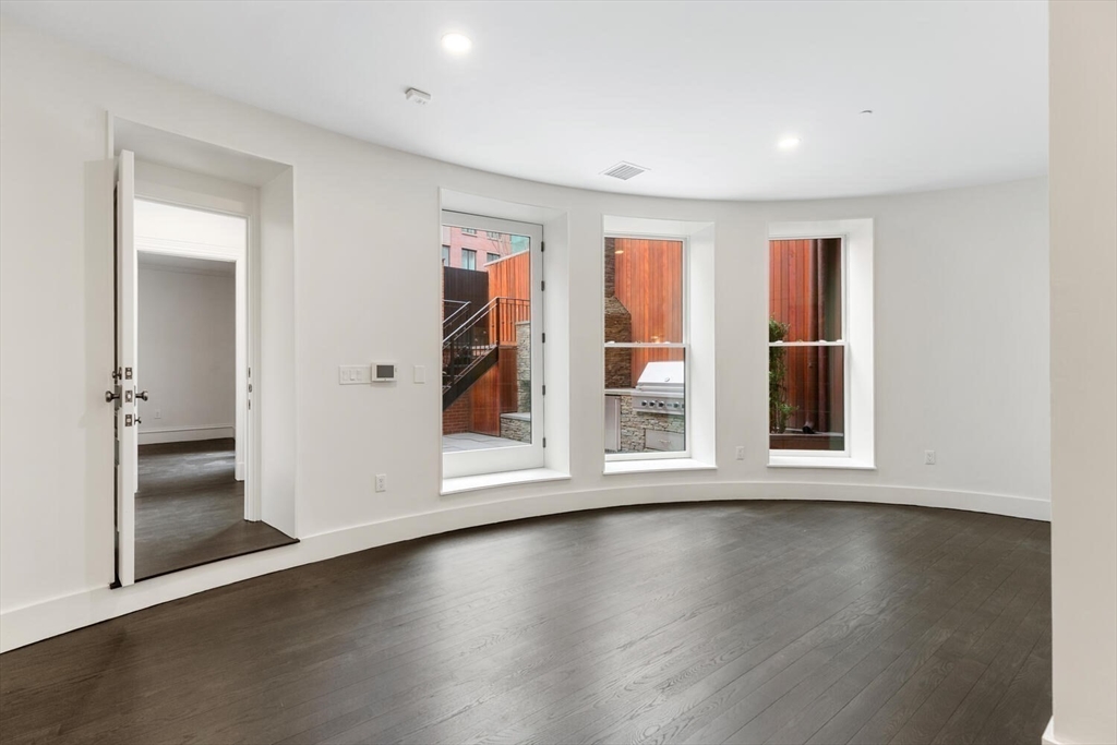 409 Commonwealth Avenue, Unit B Boston, MA 02215 - Photo 29 of 42 an empty room with wooden floor and windows