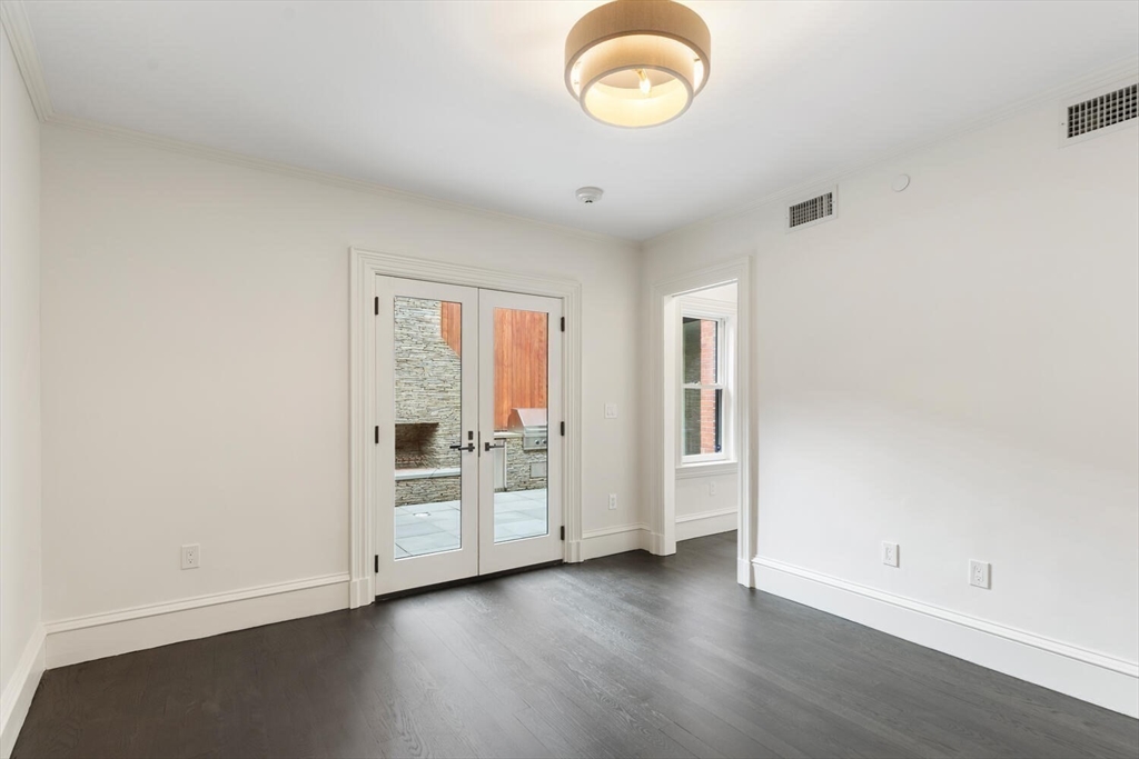 409 Commonwealth Avenue, Unit B Boston, MA 02215 - Photo 32 of 42 an empty room with wooden floor and windows