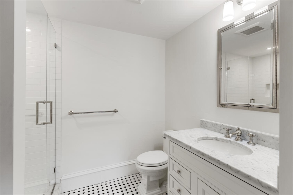 409 Commonwealth Avenue, Unit B Boston, MA 02215 - Photo 33 of 42 a bathroom with a granite countertop toilet a sink and a mirror