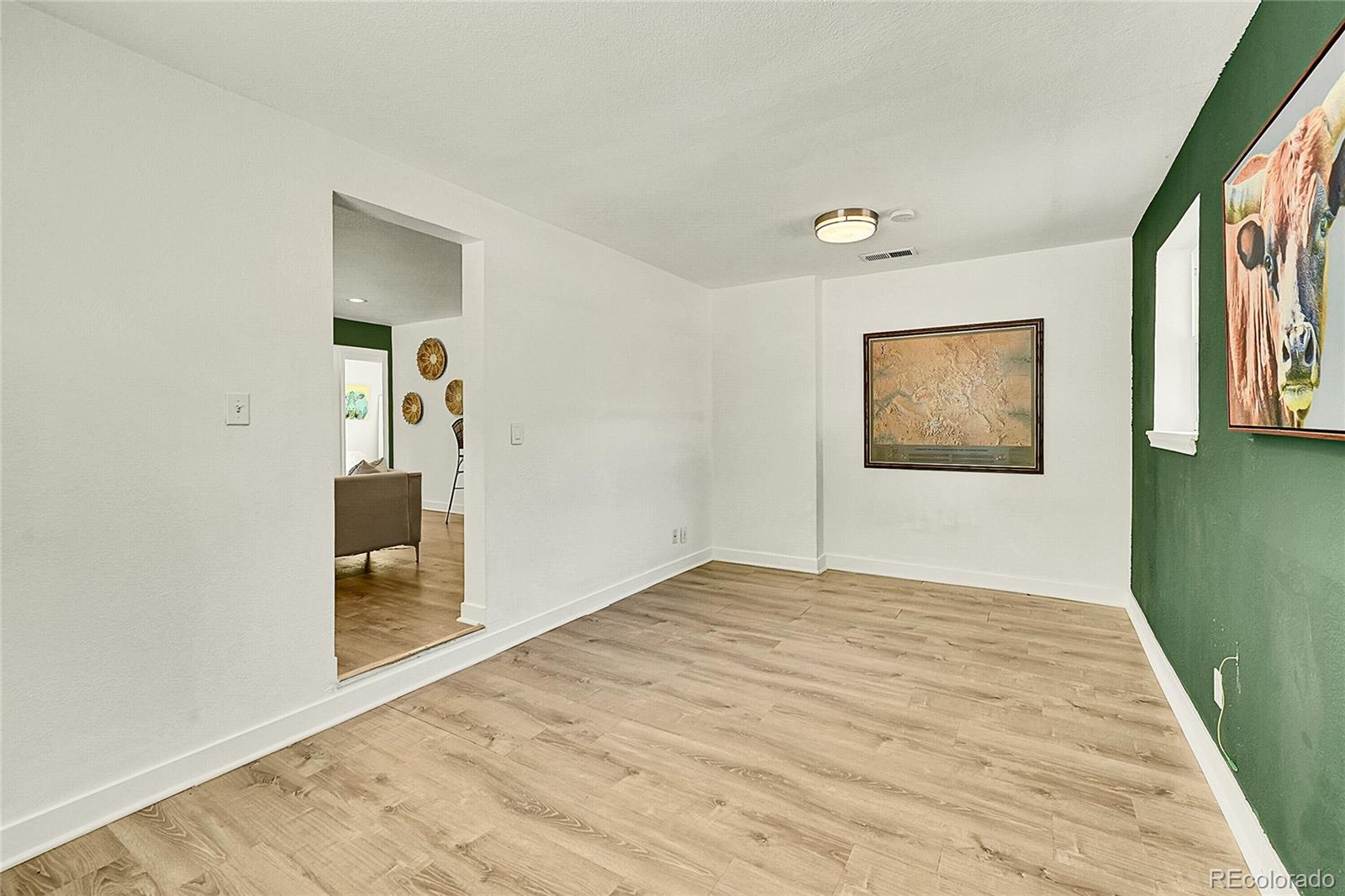 3011 Grape Street Denver, CO 80207 - Photo 16 of 42 a view of an empty room with wooden floor and a window