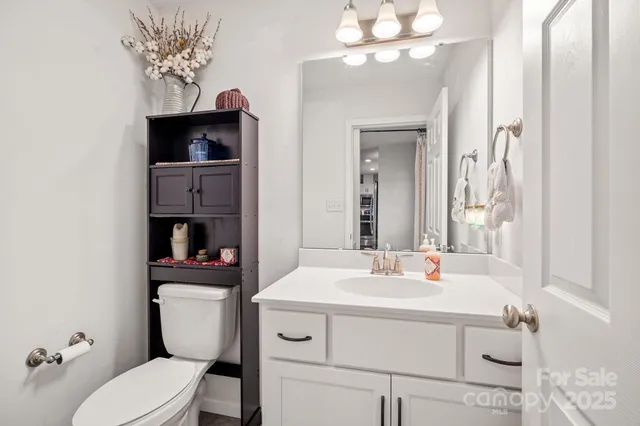 a bathroom with a sink vanity mirror and toilet