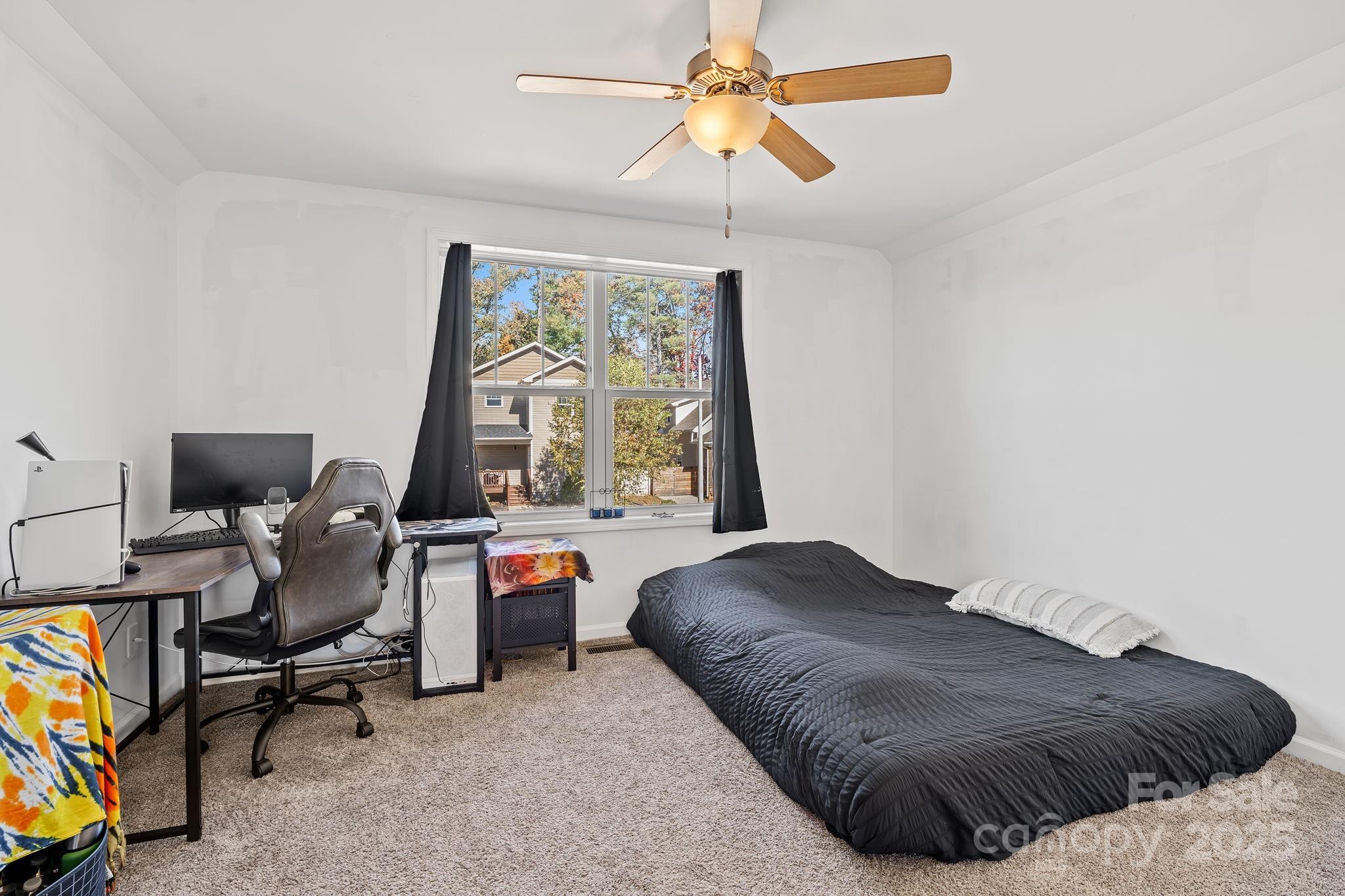 28 Yarrow Meadow Road Weaverville, NC 28787 - Photo 23 of 29 a bedroom with a bed and a chandelier