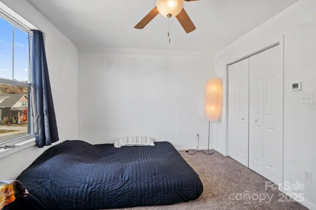 a bedroom with a bed and a large window