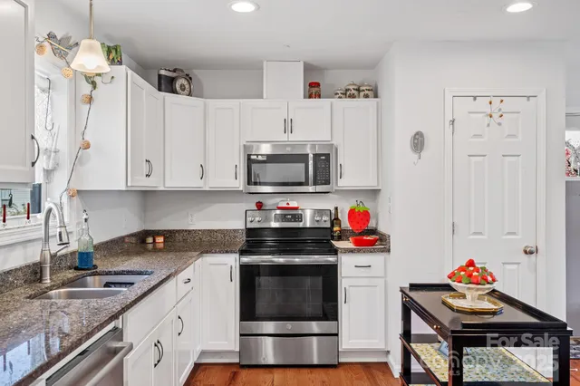 a kitchen with stainless steel appliances granite countertop a stove and a sink