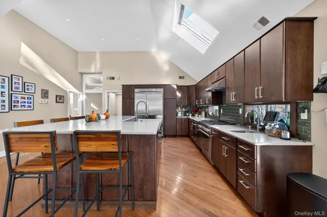 a kitchen with stainless steel appliances granite countertop a sink a stove and a refrigerator