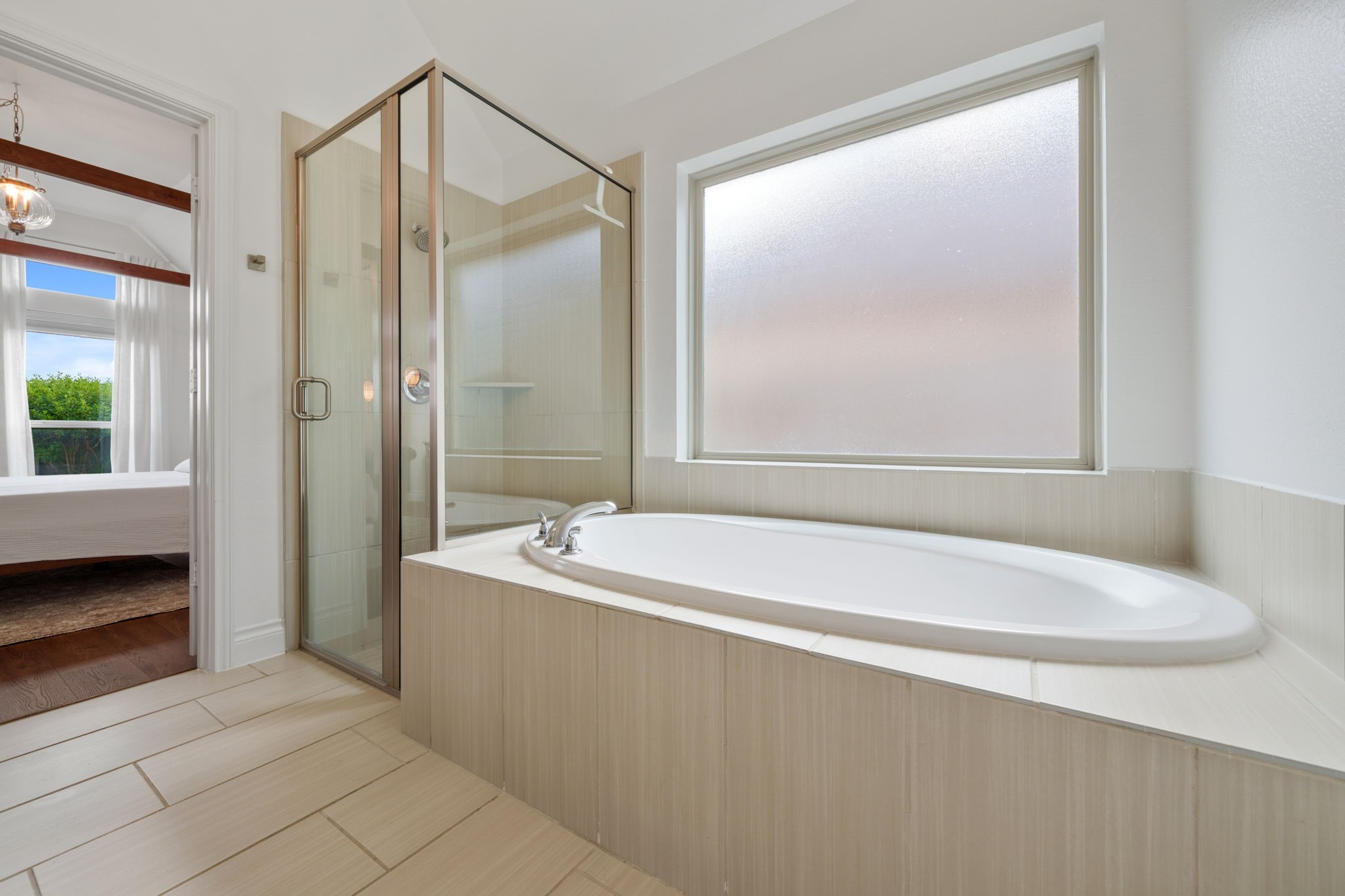 2119 Blackhawk Ridge Lane Manvel, TX 77578 - Photo 18 of 49 Primary Bathroom Soaking Tub & Walk-In Shower
The ultimate spa-like retreat awaits in the primary bathroom, featuring a generously sized soaking tub. Adjacent glass-enclosed walk-in shower - the perfect place to unwind at the end of the day. Direct views into the serene primary bedroom complete this tranquil sanctuary.