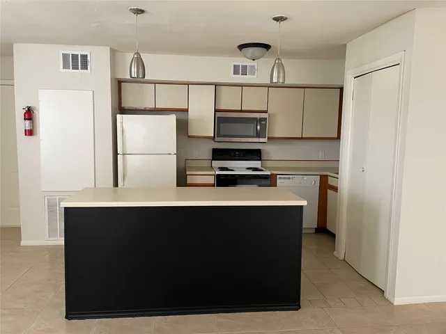 a kitchen with stainless steel appliances a refrigerator and a cabinets