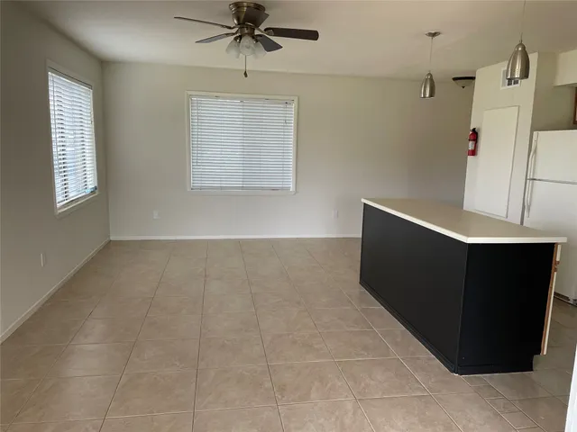 a view of an empty room with a cabinet and a window