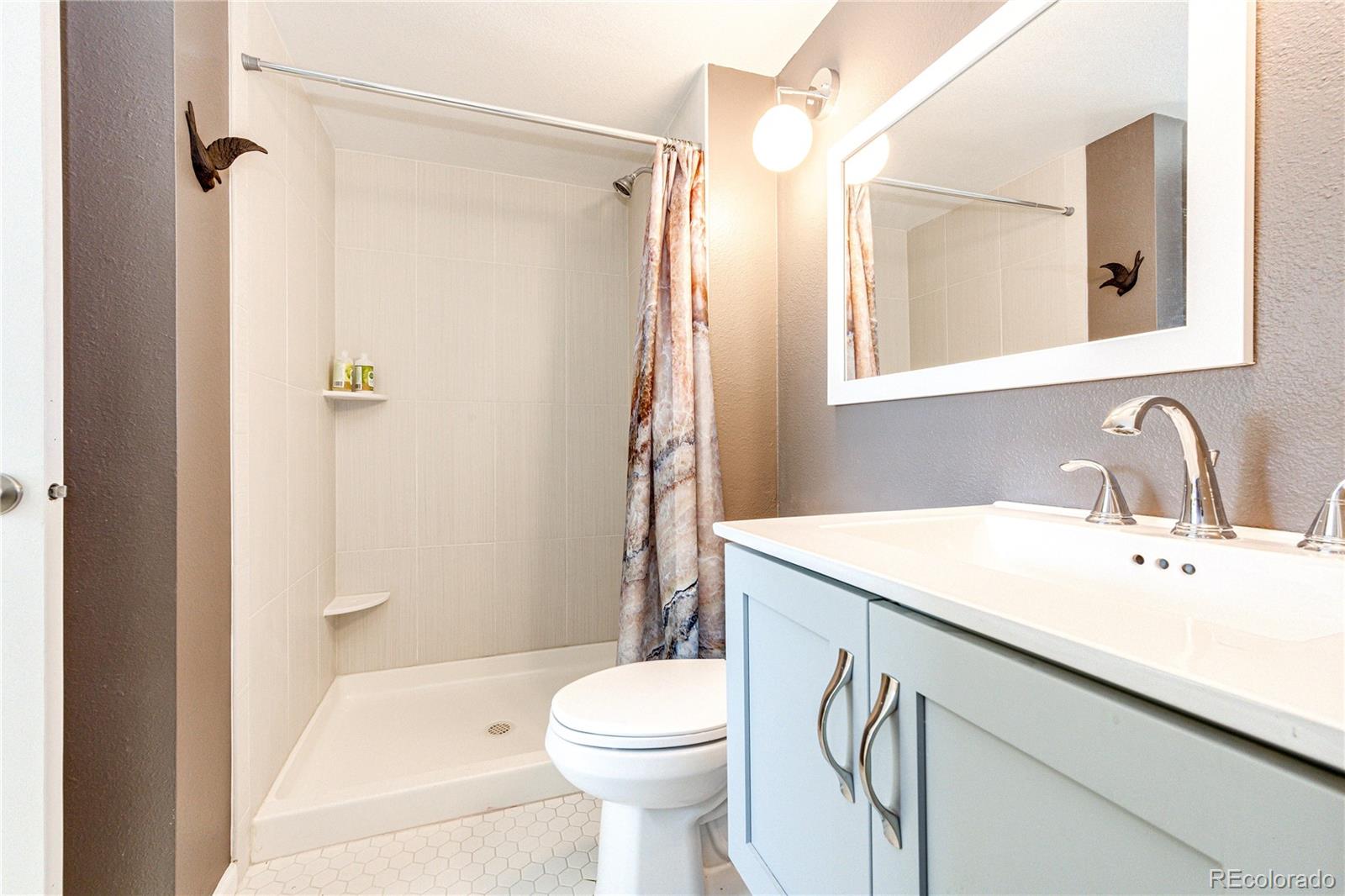 8712 Independence Way Arvada, CO 80005 - Photo 13 of 40 a bathroom with a sink a toilet and shower