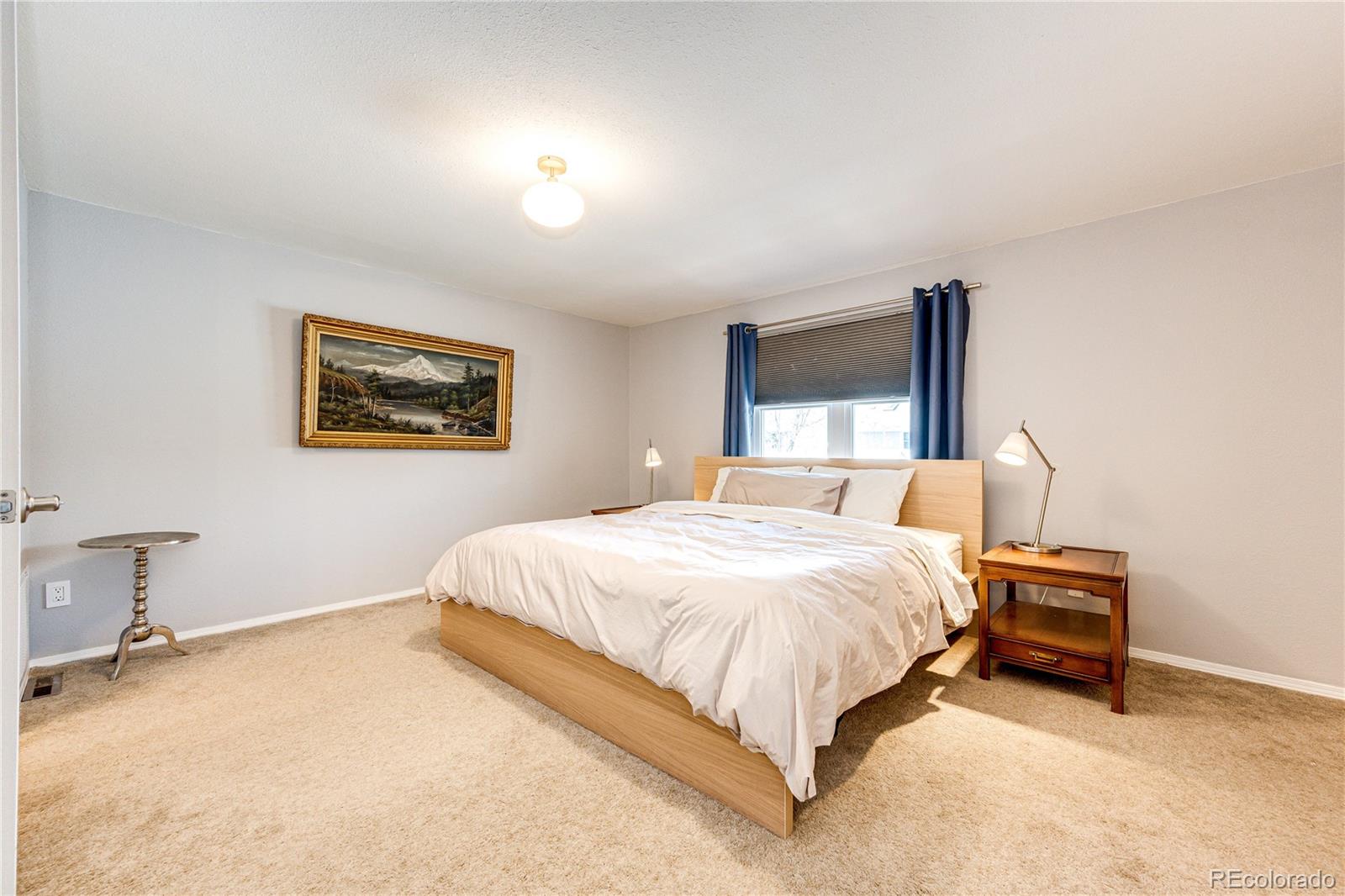 8712 Independence Way Arvada, CO 80005 - Photo 15 of 40 a spacious bedroom with a bed and a desk