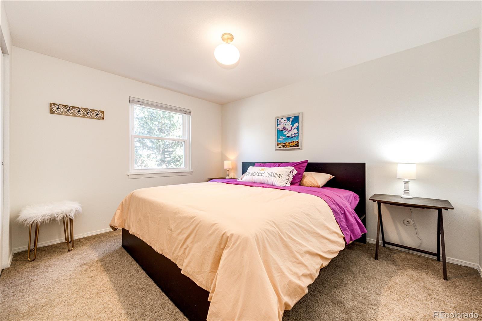 8712 Independence Way Arvada, CO 80005 - Photo 20 of 40 a bedroom with a bed and a lamp