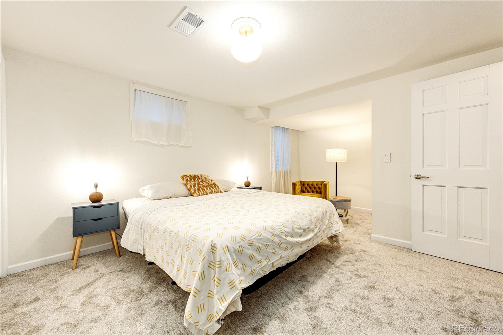 8712 Independence Way Arvada, CO 80005 - Photo 27 of 40 a bedroom with a bed and a lamp