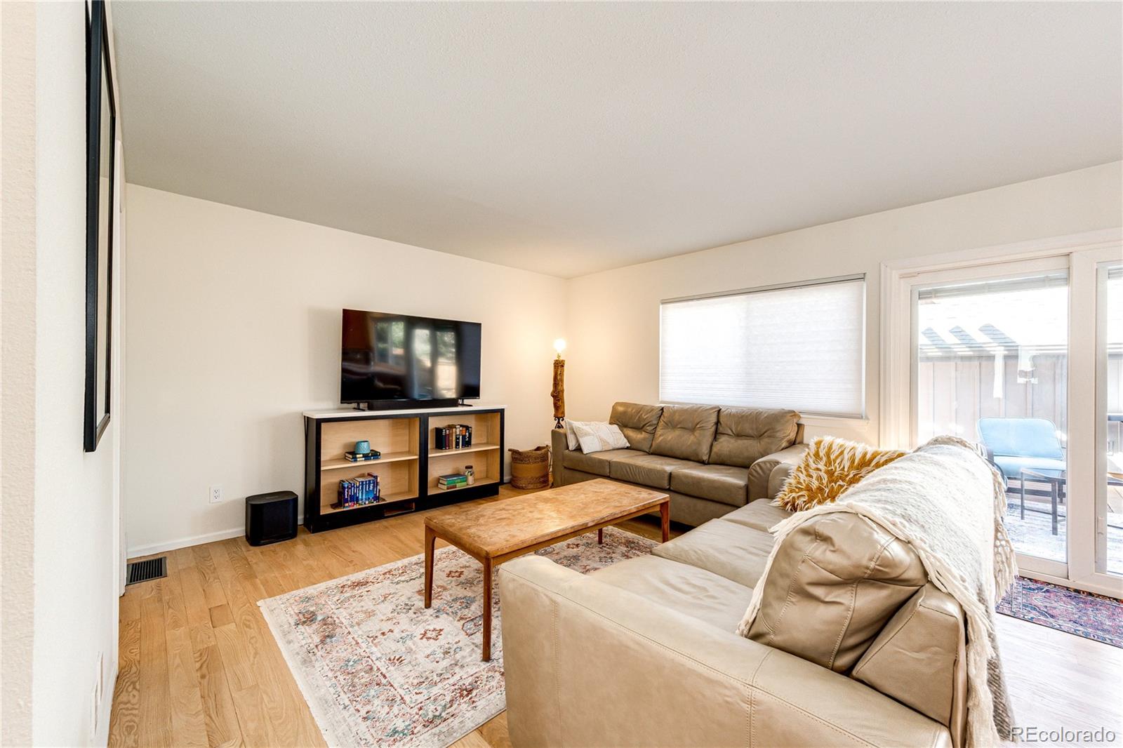 8712 Independence Way Arvada, CO 80005 - Photo 10 of 40 a living room with furniture and a flat screen tv