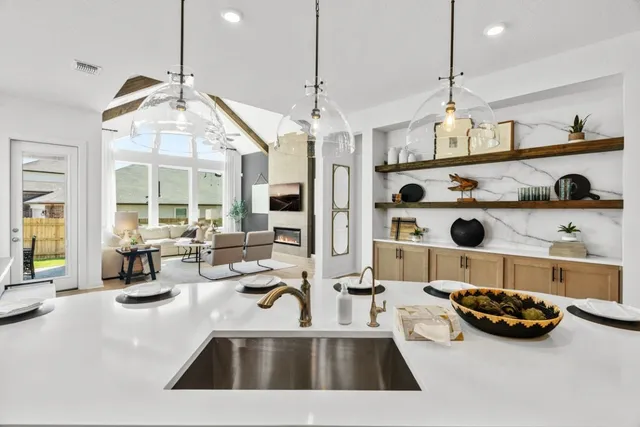 a kitchen with stainless steel appliances kitchen island granite countertop a stove a refrigerator a oven a sink with a dining table and chairs