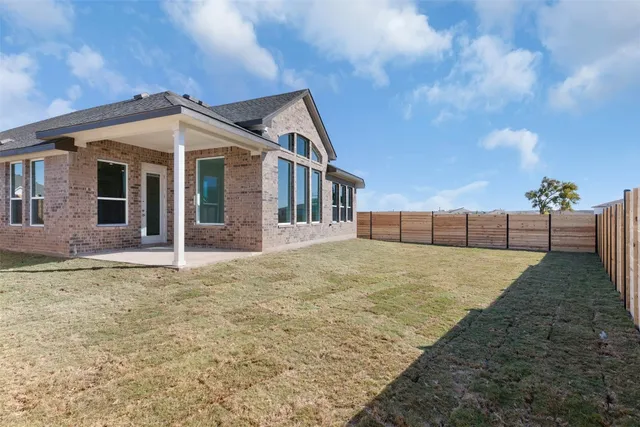 a view of a house with backyard and fence
