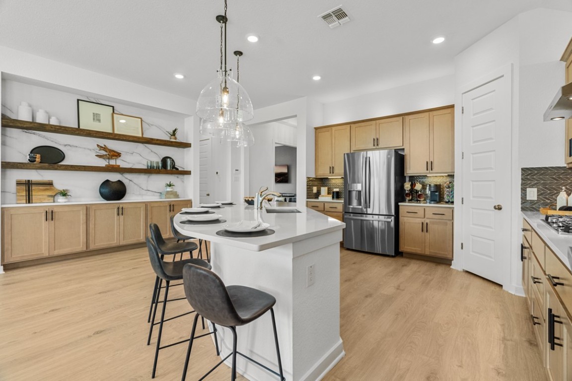 1300 Snowdrop Drive Georgetown, TX 78628 - Photo 7 of 28 a kitchen with refrigerator a sink and cabinets