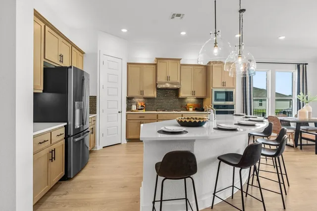 a kitchen with stainless steel appliances a stove a sink island and a refrigerator