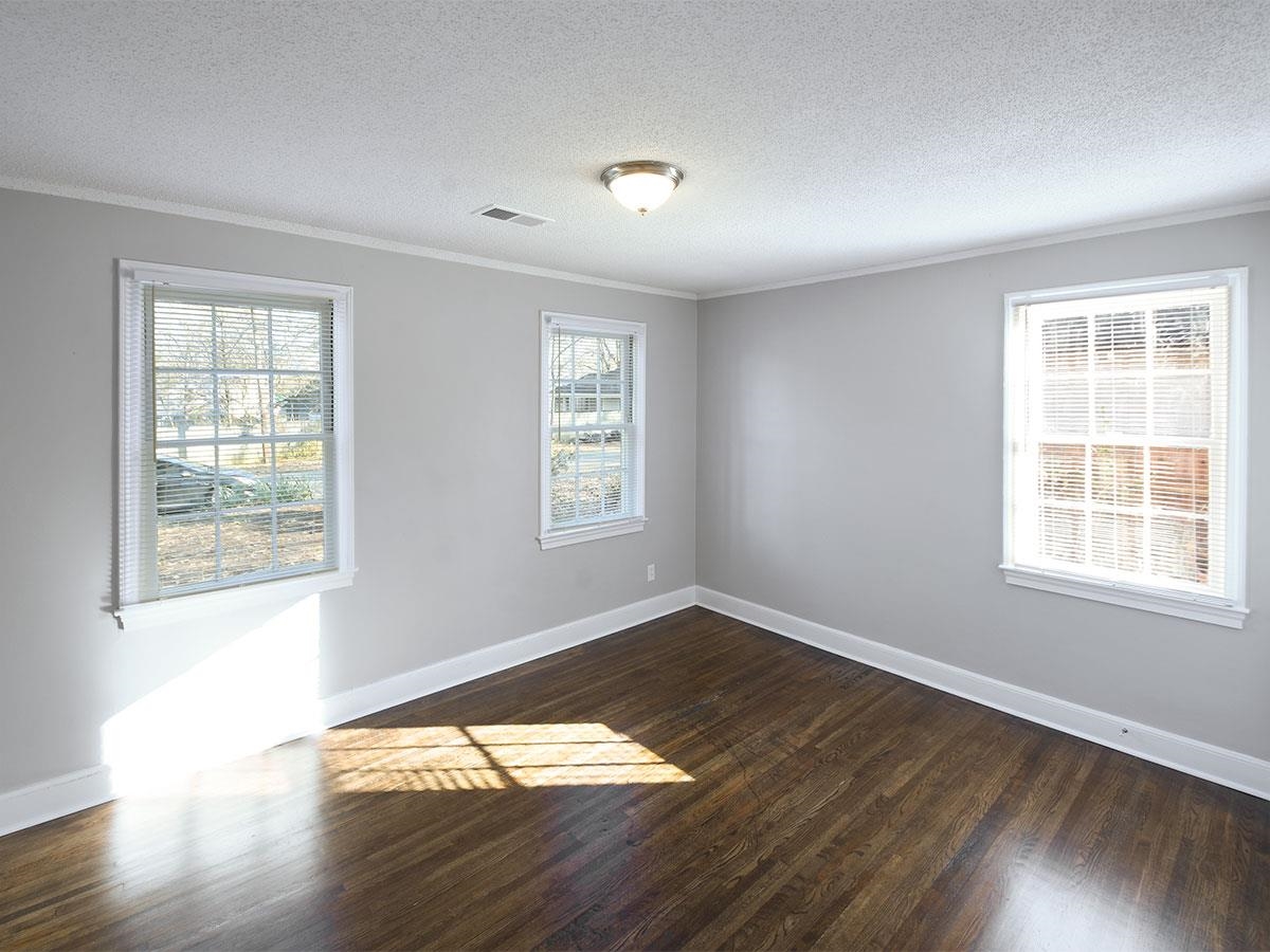 1019 Little John Road Memphis, TN 38111 - Photo 7 of 13 Empty room with a textured ceiling, crown molding, and dark wood-type flooring