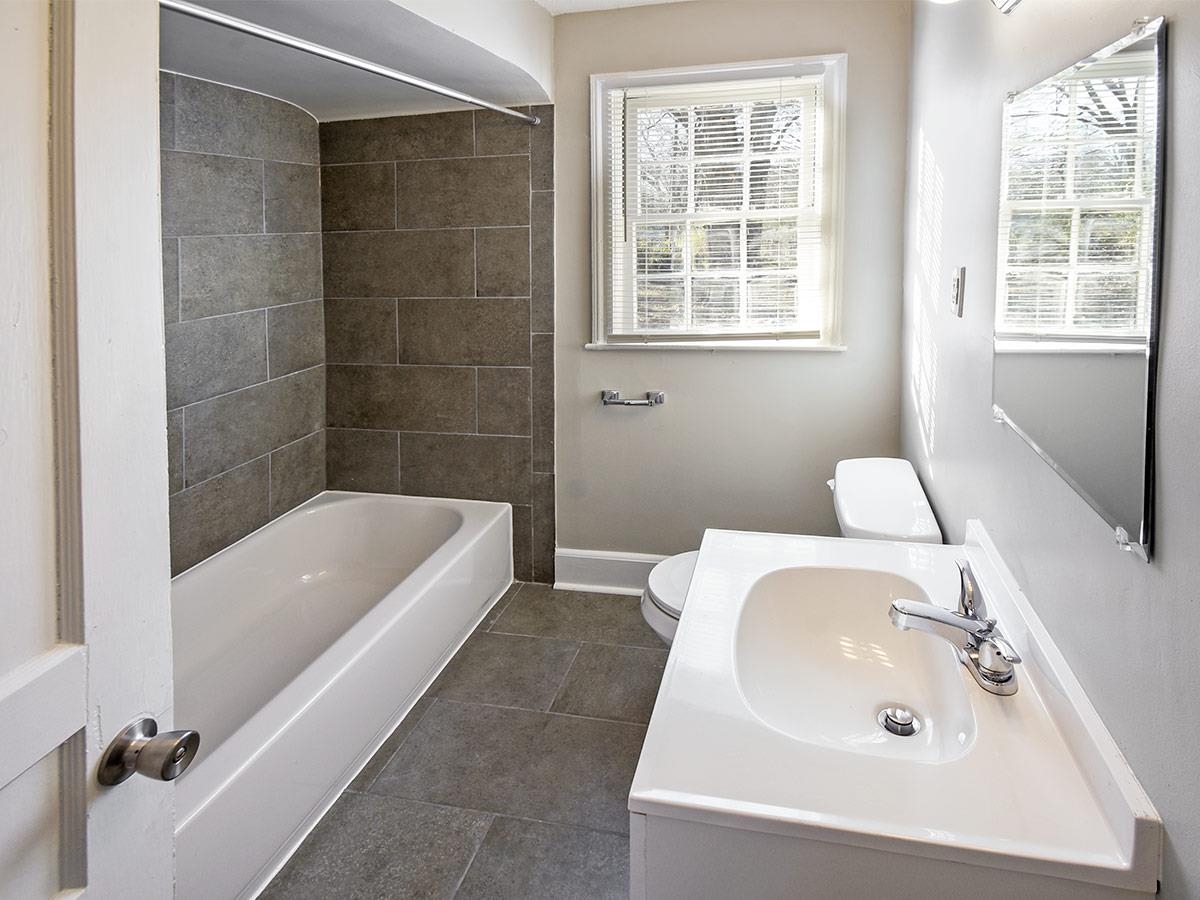 1019 Little John Road Memphis, TN 38111 - Photo 9 of 13 Full bathroom featuring tile patterned floors, tiled shower / bath combo, toilet, and a wealth of natural light