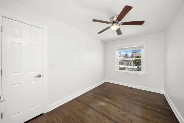 a view of a hallway with wooden floor and a ceiling fan