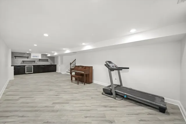 a room with gym equipment and wooden floor