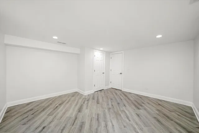 a view of room with wooden floor and white walls