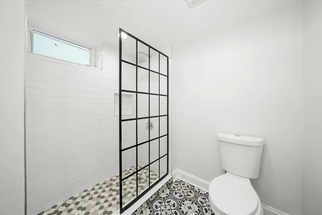 a bathroom with a toilet and a shower