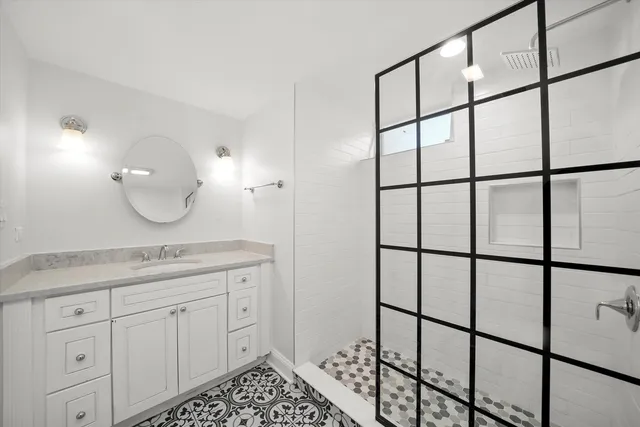 a bathroom with a granite countertop sink and a mirror